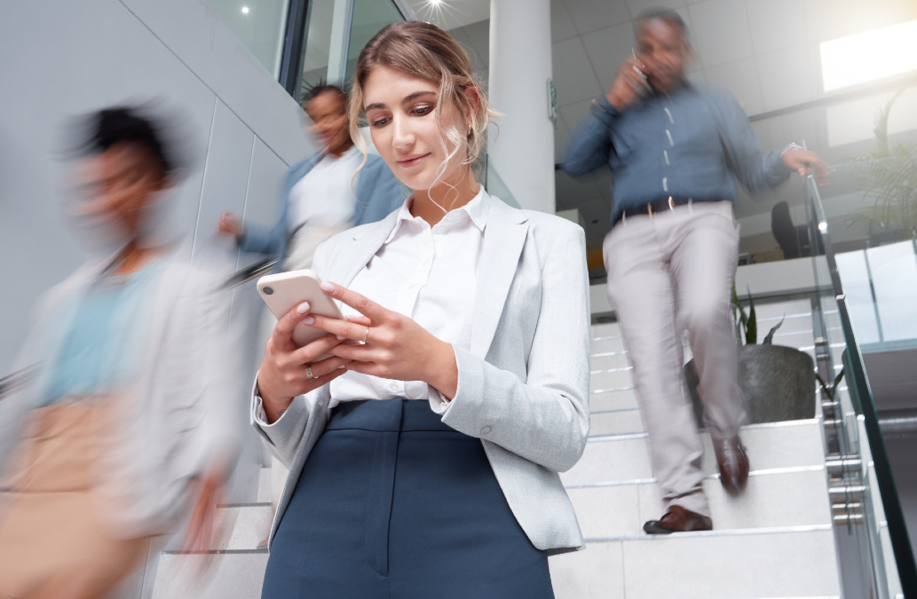 Women in corporate office scrolling through her phone