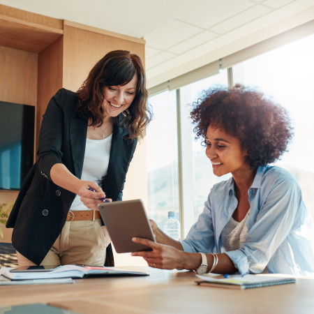 two business people in office, looking at tablet