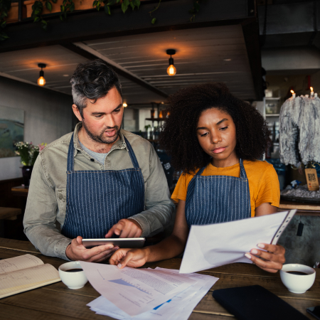 two individuals looking over business papers