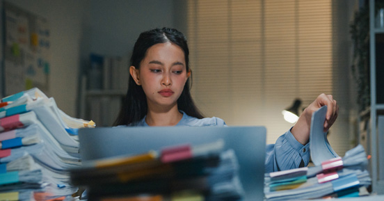 Woman working through stack of documents